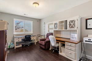 Office featuring dark wood-type flooring and baseboards