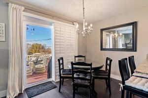 Dining area with a chandelier and dark wood finished floors
