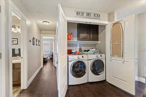 Laundry room featuring washer and clothes dryer and dark wood finished floors