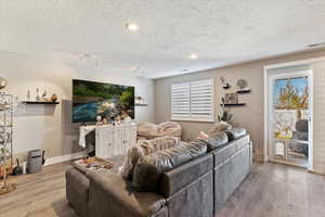 Living room featuring wood finished floors, healthy amount of natural light, and a textured ceiling