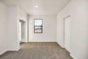 Unfurnished bedroom featuring carpet and baseboards