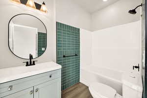 Full bath featuring vanity, shower / washtub combination, and dark wood finished floors