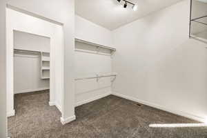 Walk in closet with dark carpet