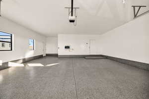 Garage with baseboards and a garage door opener