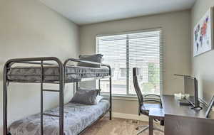 Bedroom with light carpet and an office area