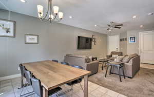 Dining area featuring light tile patterned floors, recessed lighting, a chandelier, and ceiling fan