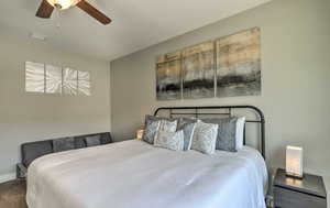 Carpeted bedroom with ceiling fan and baseboards