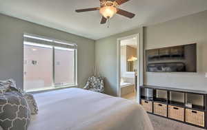 Bedroom featuring ceiling fan, carpet, and ensuite bath