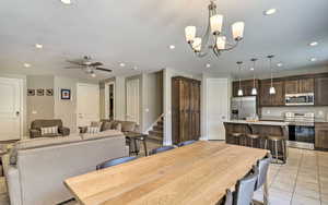 Dining room featuring stairway, ceiling fan, recessed lighting, and a chandelier