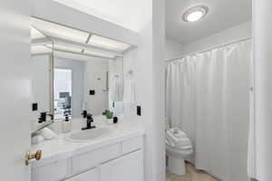 Full bath with a shower with shower curtain, vanity, and light tile patterned flooring