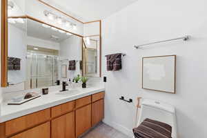 Full bath featuring a shower stall, vanity, and light tile patterned flooring