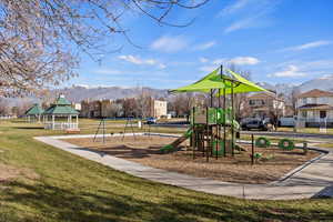Community playground with a mountain view, a lawn, and a gazebo