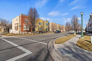 View of asphalt street with sidewalks, street lighting, curbs, and a residential view