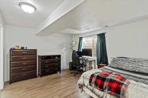 Bedroom with a desk and light wood-style flooring