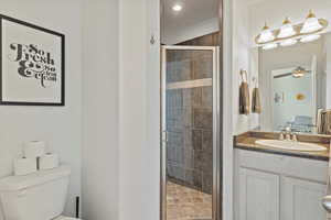 Full bath with vanity, a stall shower, and a ceiling fan