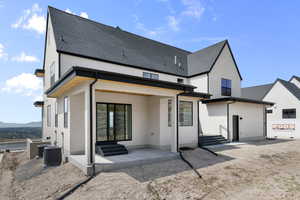 Back of property with a patio area, stucco siding, and roof with shingles