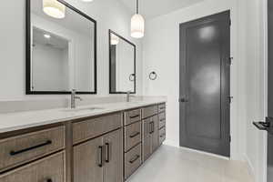Bathroom with double vanity and light tile patterned floors