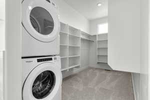 Washroom featuring light carpet and estacked washer and dryer