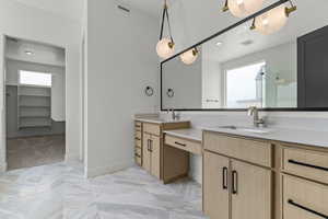 Bathroom with a shower stall, a spacious closet, and double vanity