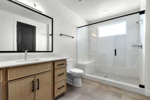 Full bath featuring a stall shower, vanity, a textured ceiling, and light tile patterned floors