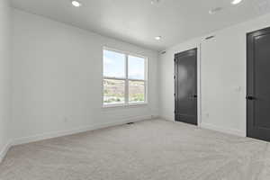 Unfurnished bedroom with carpet floors and recessed lighting