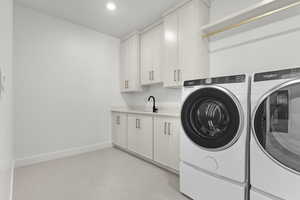 Washroom with washer and dryer, cabinet space, and recessed lighting
