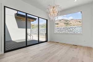 Unfurnished dining area featuring a chandelier, light wood finished floors, and a mountain view