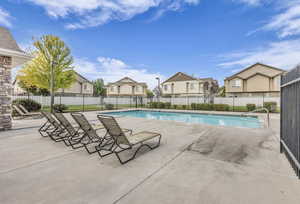 Community pool featuring a patio and a residential view