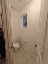 Bathroom featuring toilet and light tile patterned floors