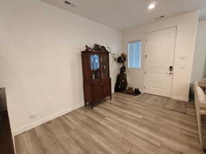 Foyer with light wood-type flooring and recessed lighting