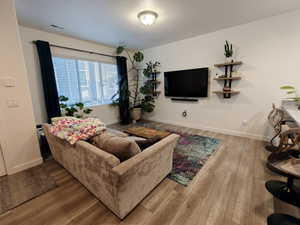 Living area with light wood finished floors and baseboards