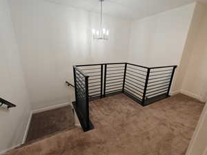 Stairway with carpet and a chandelier