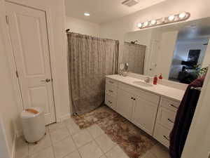 Full bath with vanity, a shower with curtain, and light tile patterned floors