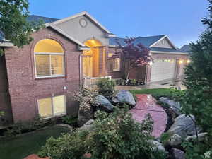 View of front of house with brick siding and an attached garage