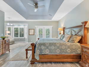 Bedroom featuring access to outside, wood finished floors, ceiling fan, and multiple windows