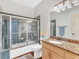 Full bath with vanity and bath / shower combo with glass door