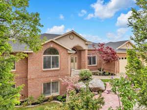 Single story home featuring roof with shingles, brick siding, and a garage