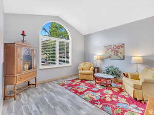 Living room with lofted ceiling and wood finished floors