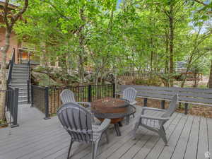 Wooden deck featuring stairway and a fire pit