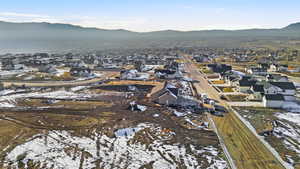 Snowy aerial view featuring a residential view and a mountain view