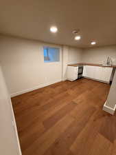 Finished below grade area with light wood-style floors and recessed lighting