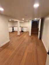 Finished basement featuring stairway, recessed lighting, and light wood-type flooring