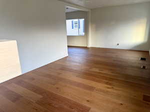 Unfurnished room with wood finished floors and baseboards