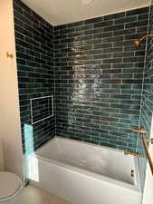 Full bathroom with shower / tub combination, tile patterned flooring, and a textured ceiling