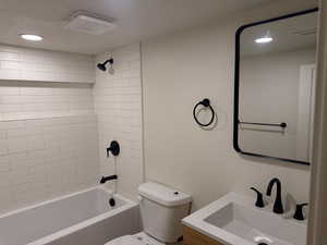 Full bathroom with vanity,  shower combination, a textured ceiling, and recessed lighting