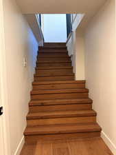 Stairs with baseboards and wood finished floors
