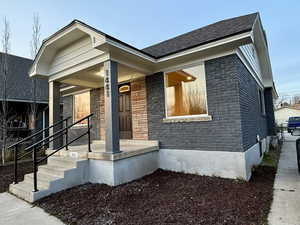 View of front of house with brick siding and covered porch