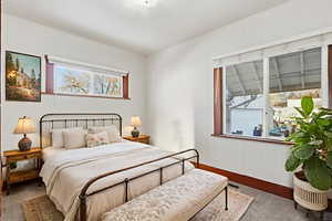 Carpeted bedroom featuring baseboards and wooden walls