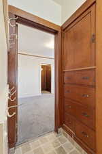 Corridor with light colored carpet and baseboards
