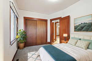 Carpeted bedroom featuring a closet and baseboards